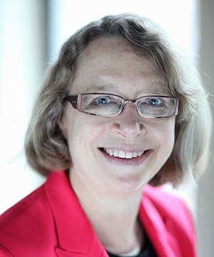 Image of Lori Damrosch wearing eyeglasses and a fuschia colored blazer